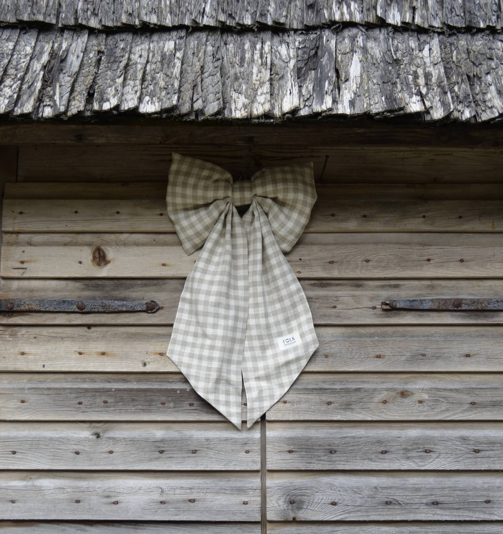 Checkered bow tie hanging on a wooden wall
