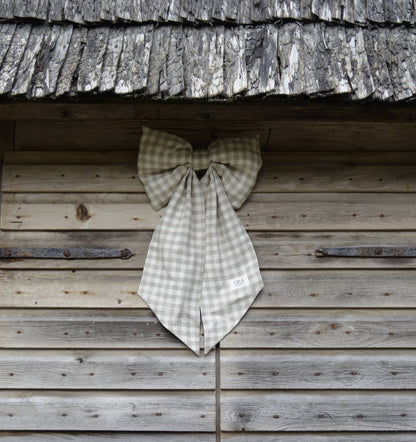 Checkered bow tie hanging on a wooden wall